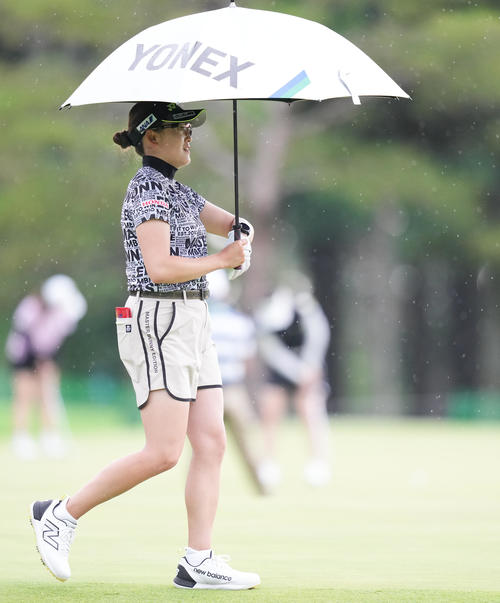 傘をさして移動する岩井千（撮影・鈴木みどり）