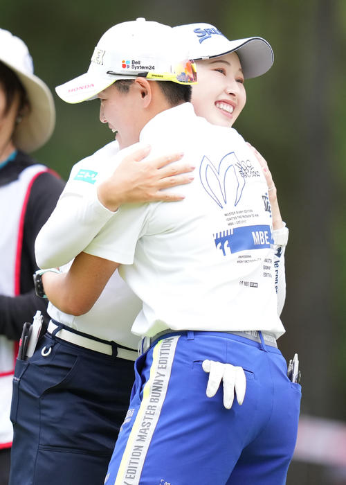 ホールアウトし、岩井明（手前）とハグする小祝（撮影・鈴木みどり）