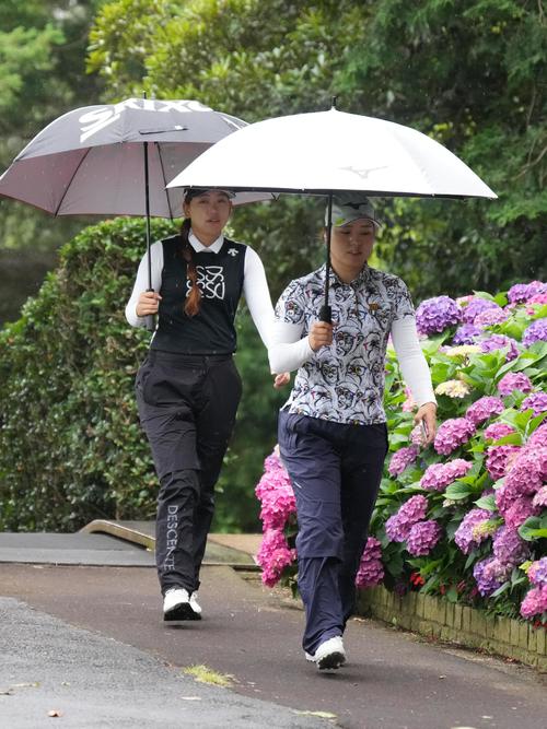 アースモンダミンカップ2日目、10番ティーへ移動する仲村(右)と荒川(撮影・小沢裕)
