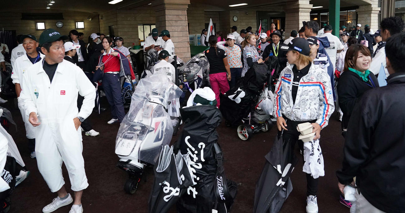 雨天のため競技が一時中断となりクラブハウス前は引き揚げてきた選手たちでごった返した（撮影・小沢裕）
