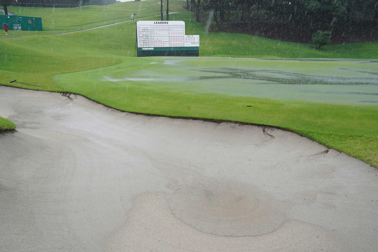 雨天のため競技が一時中断となり16番グリーンとバンカーには水たまりができた（撮影・小沢裕）