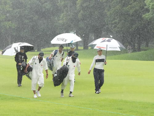 アースモンダミンカップ2日目、12番、雨のため競技が一時中断となりコースを引き揚げる高橋（右）ら選手たち（撮影・小沢裕）