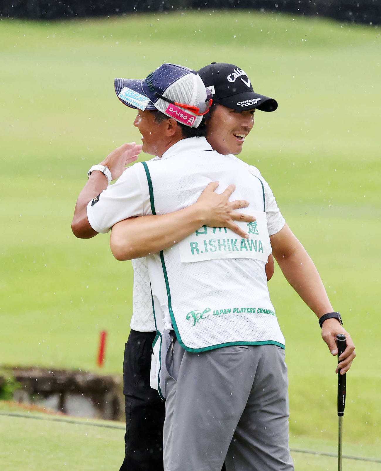 優勝し佐藤キャディー（手前）と抱き合い喜ぶ石川（撮影・鈴木正人）