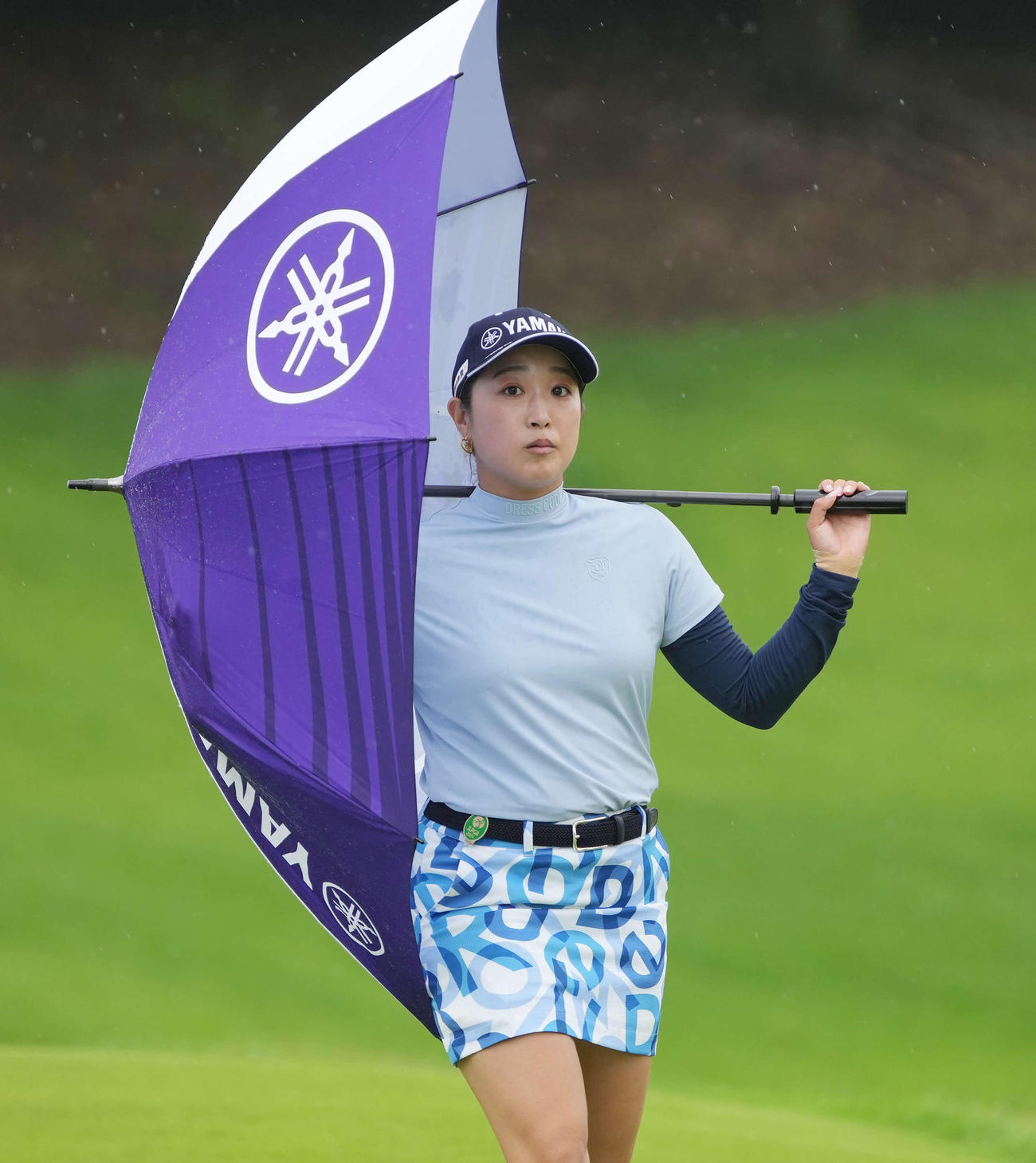 16番、横から降る雨を傘で遮る高木優（撮影・小沢裕）