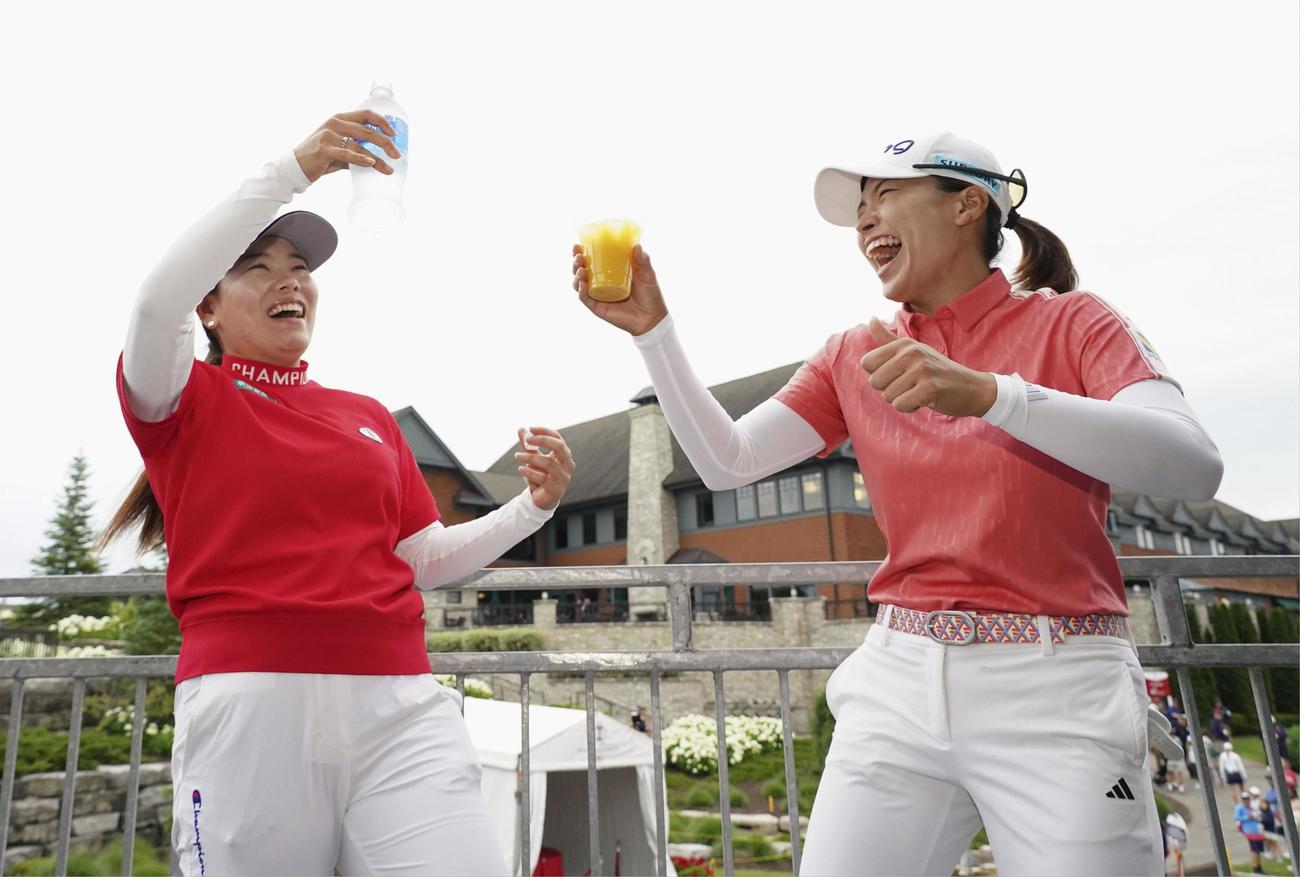 ホールインワンのお祝いに大会側が用意した飲み物で乾杯する渋野（右）と勝（共同）