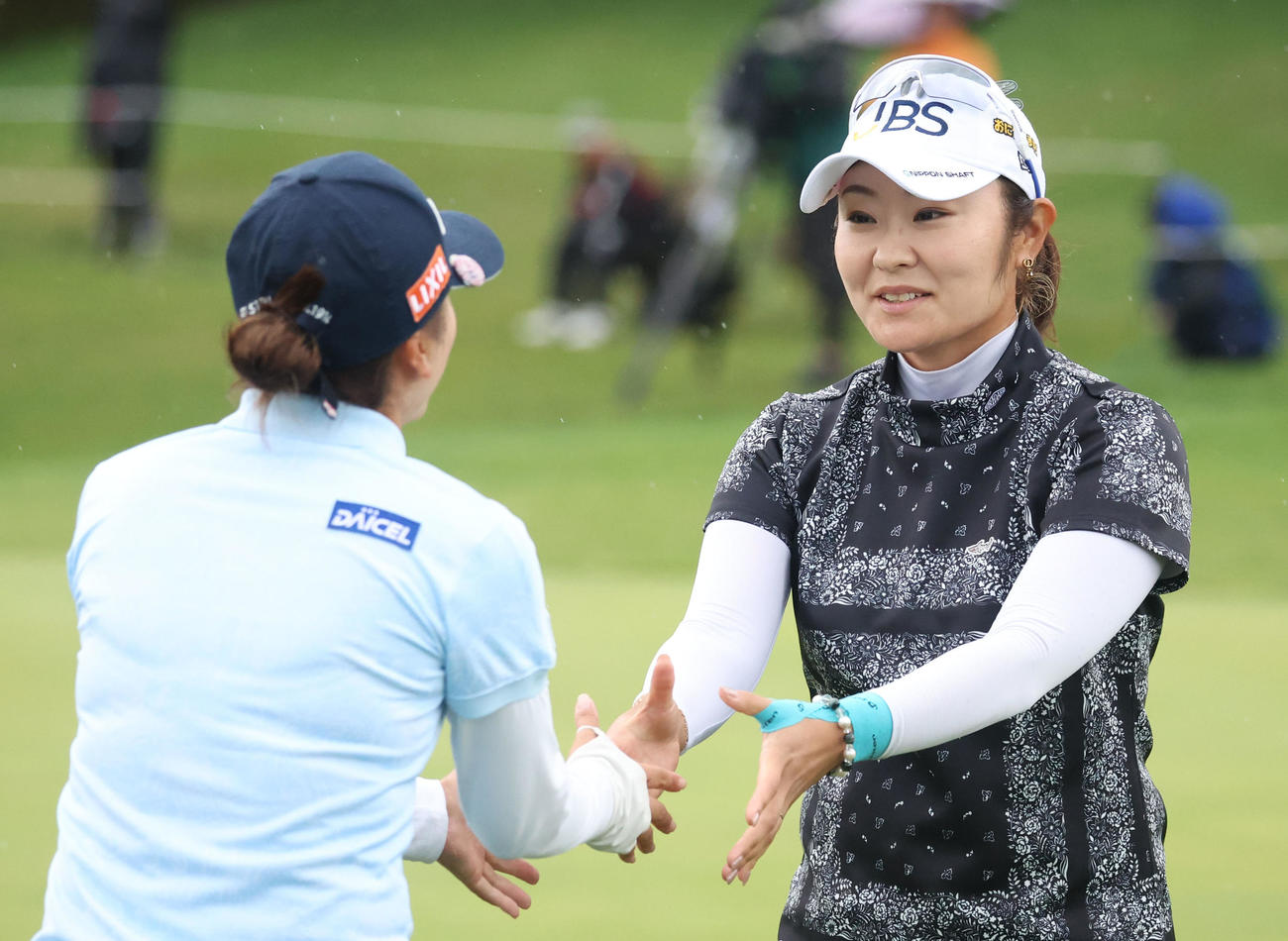 18番、ホールアウトし堀（左手前）と握手をする藤田（撮影・佐藤翔太）