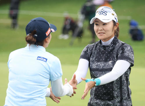 18番、ホールアウトし堀（左手前）と握手をする藤田（撮影・佐藤翔太）