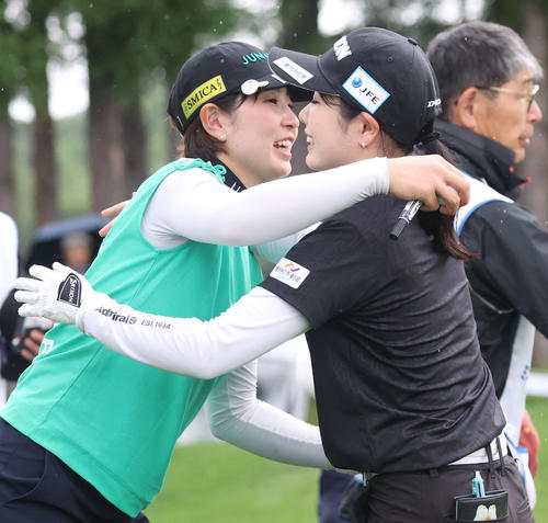 18番、ホールアウトし抱き合う蛭田（左）と尾関（撮影・佐藤翔太）