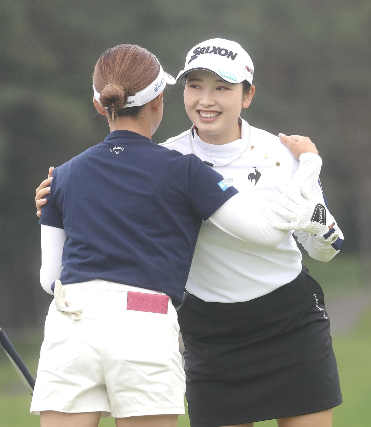 9番、ホールアウトし政田（左手前）と抱き合う小祝（撮影・佐藤翔太）