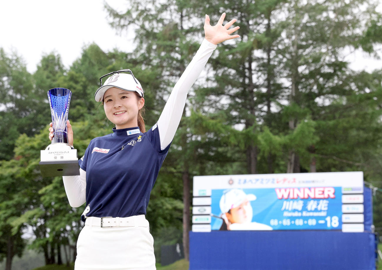 優勝トロフィーを手に笑顔で記念撮影をする川崎（撮影・佐藤翔太）