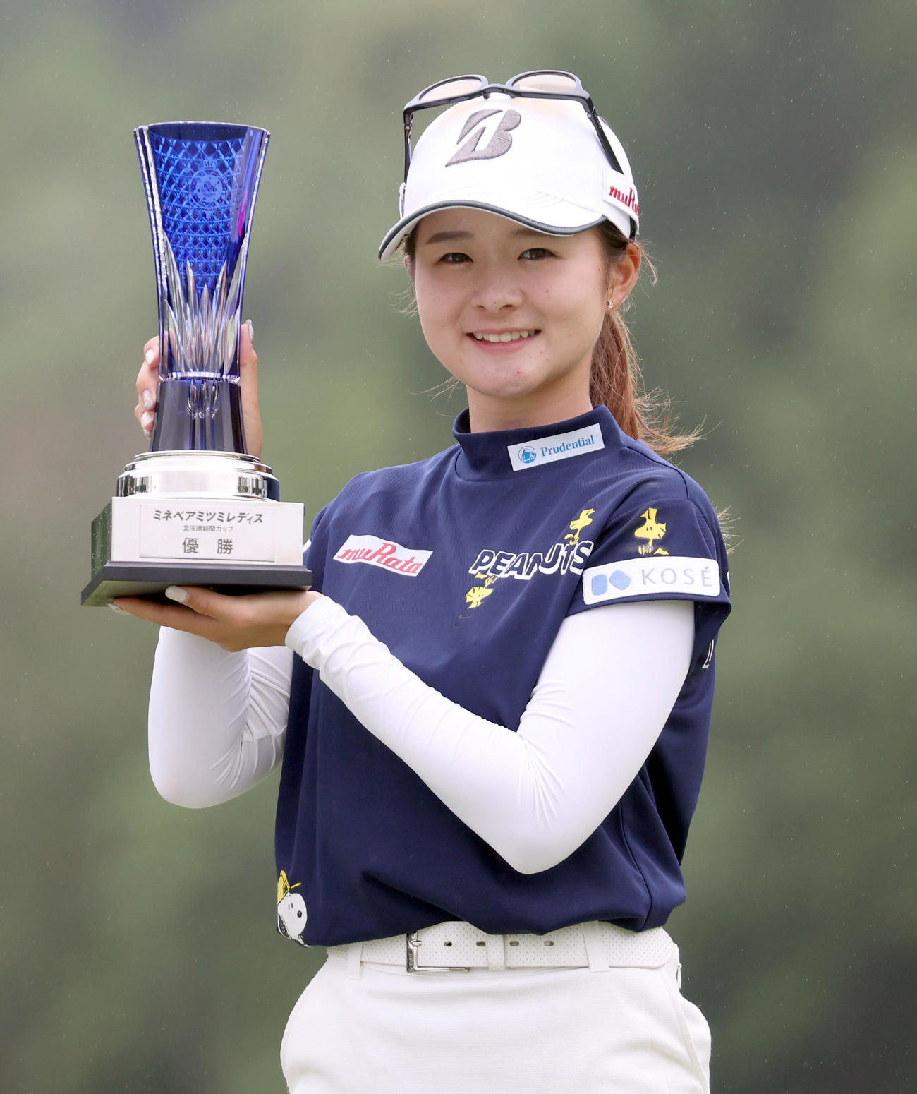 優勝トロフィーを手に笑顔で記念撮影をする川崎（撮影・佐藤翔太）