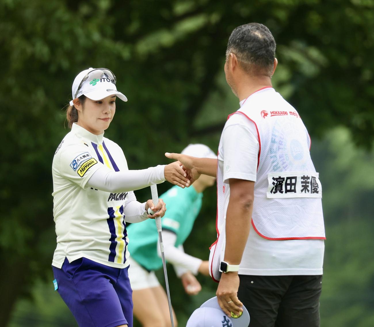 18番、バーディーパットを決めキャディーと握手する浜田（撮影・佐藤翔太）
