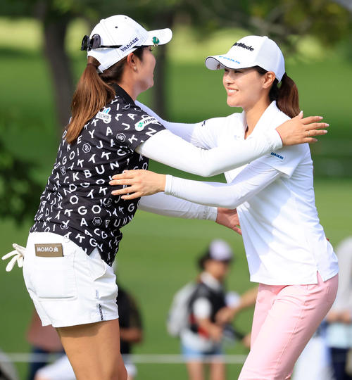 2日目、18番を終え、笑顔で抱擁する大里（左）と新垣（撮影・浅見桂子）