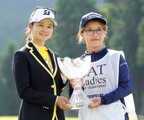 優勝カップを手にキャディーを務めた大窪ネネさんと記念撮影に納まる川崎春花（撮影・たえ見朱実）