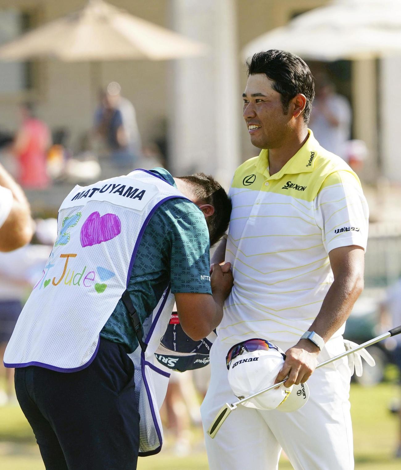 最終ラウンド、通算17アンダーで優勝を果たしキャディーと喜ぶ松山英樹（右、共同）