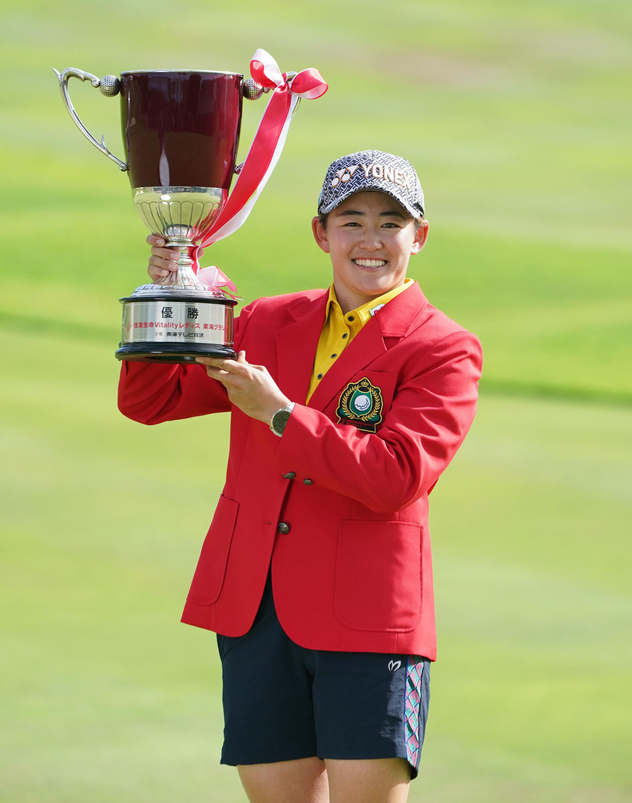 通算16アンダーで優勝、大会2連覇を達成し笑顔で優勝カップを掲げる岩井明（撮影・森本幸一）