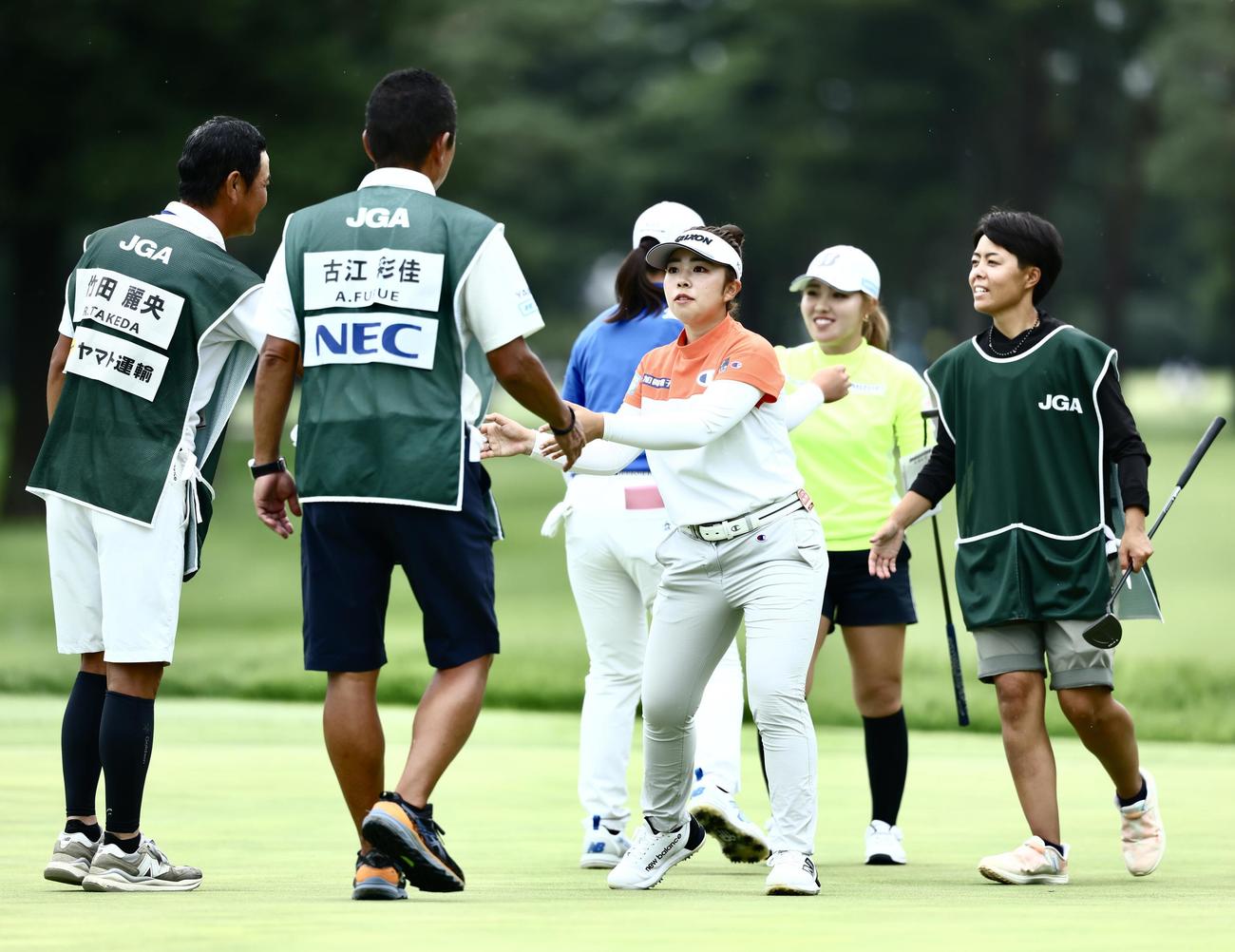 ホールアウトし、キャディーと握手を交わす山下（中央）（撮影・河田真司）