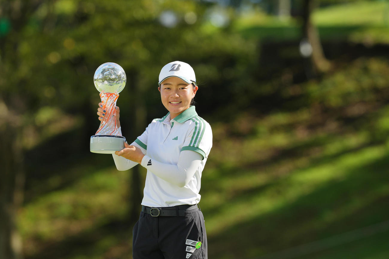 優勝トロフィーを手に写真に納まる佐藤（撮影・垰建太）