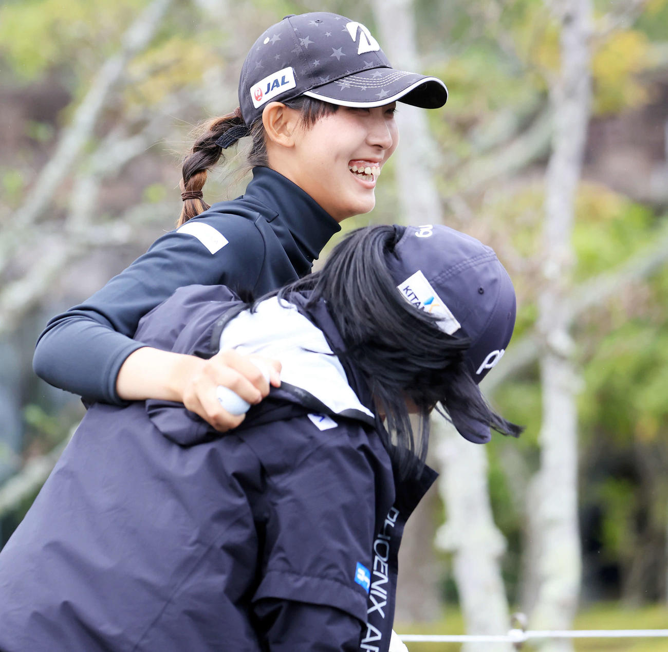 笑顔で選手と抱き合う馬場（撮影・浅見桂子）