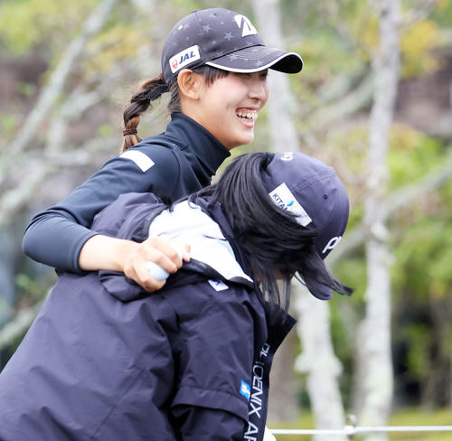 笑顔で選手と抱き合う馬場（撮影・浅見桂子）
