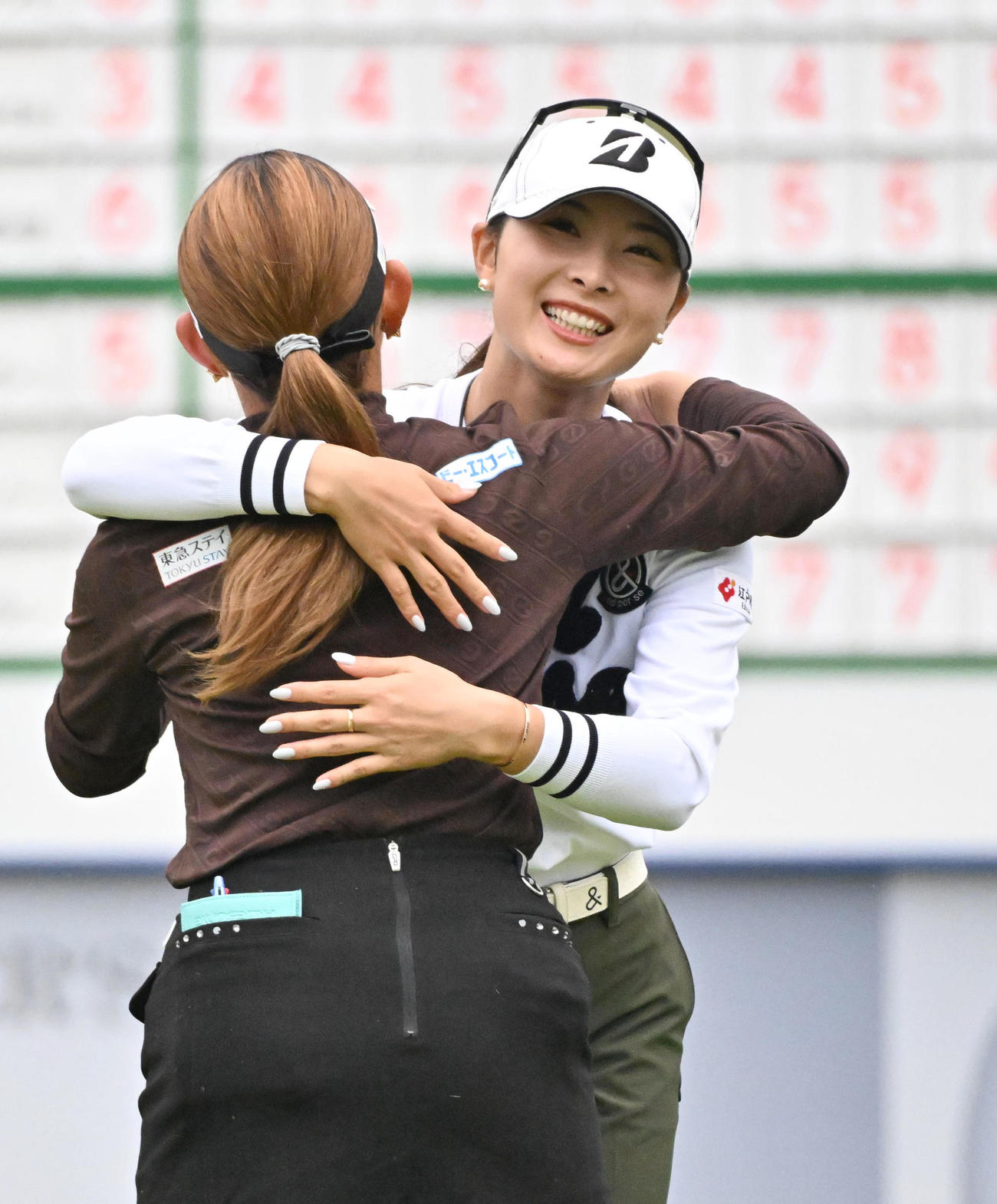 18番ホール、鶴岡果恋（右）は18番ホールを終え吉本ひかると抱き合う（撮影・石井愛子）