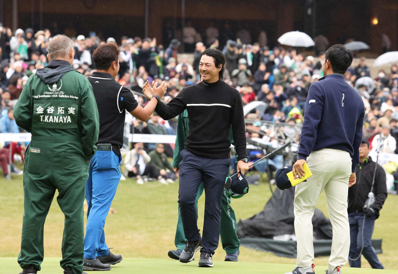 18番、逆転優勝を飾り同組の佐藤と金谷の祝福を受ける石川遼（撮影・丹羽敏通）