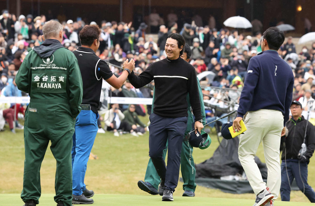 18番、逆転優勝を飾り同組の佐藤と金谷の祝福を受ける石川遼（撮影・丹羽敏通）