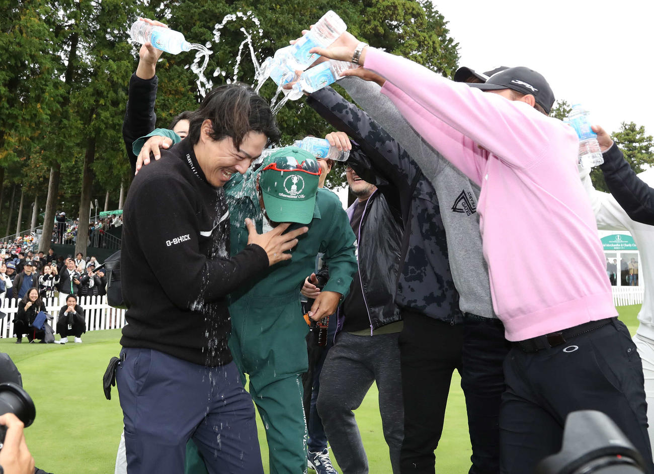 逆転優勝して佐藤キャディーと共にウォーターシャワーの祝福を受ける石川遼（撮影・丹羽敏通）