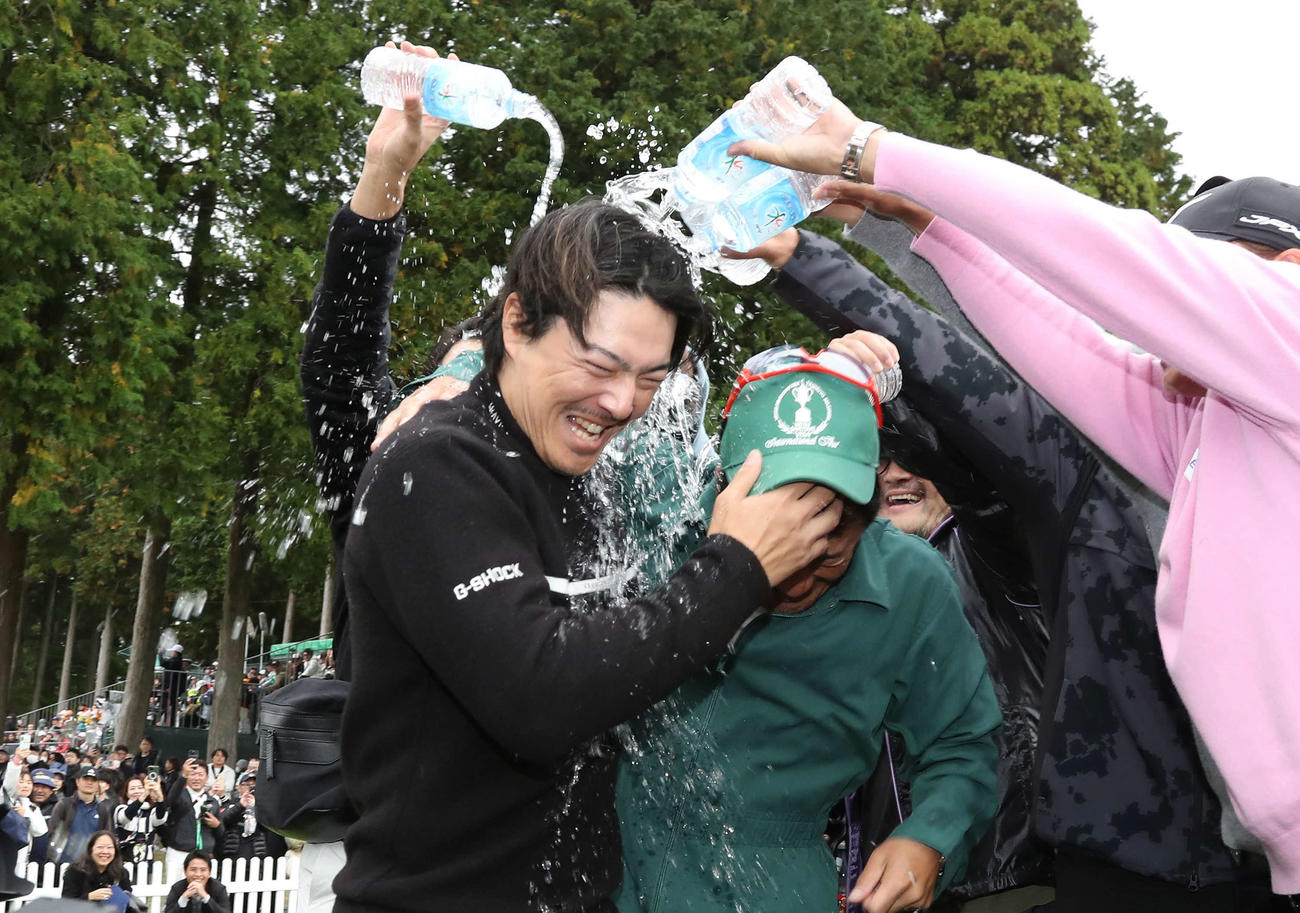 逆転優勝して佐藤キャディーと共にウォーターシャワーの祝福を受ける石川遼（撮影・丹羽敏通）