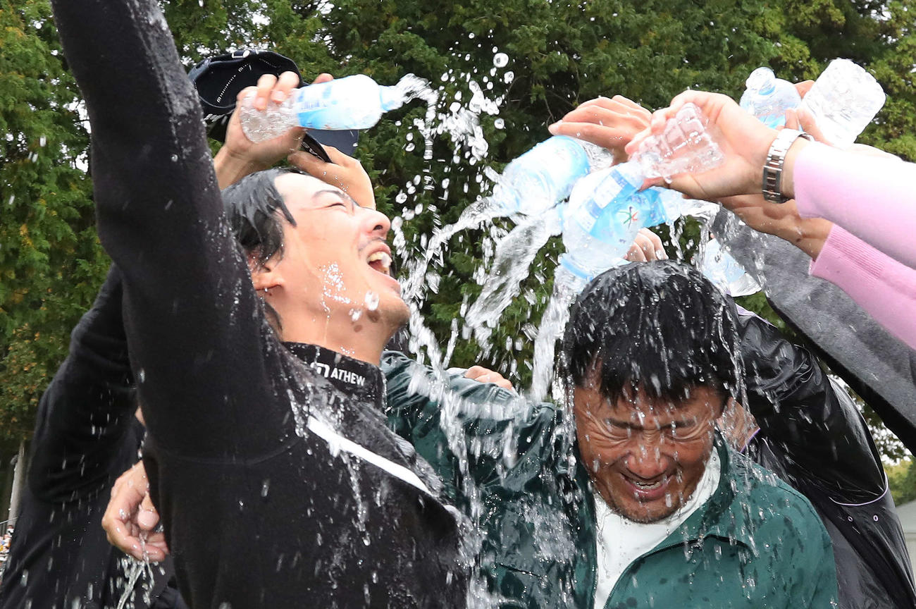 逆転優勝を果たし佐藤キャディー（右）とウォーターシャワーの祝福を受ける石川（撮影・丹羽敏通）