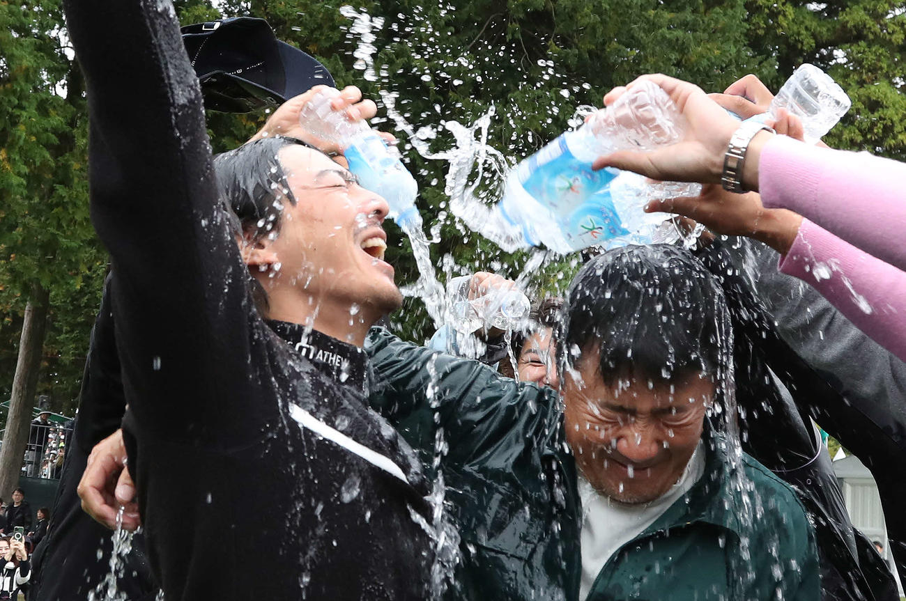 逆転優勝して佐藤キャディーと共にウォーターシャワーの祝福を受ける石川遼（撮影・丹羽敏通）