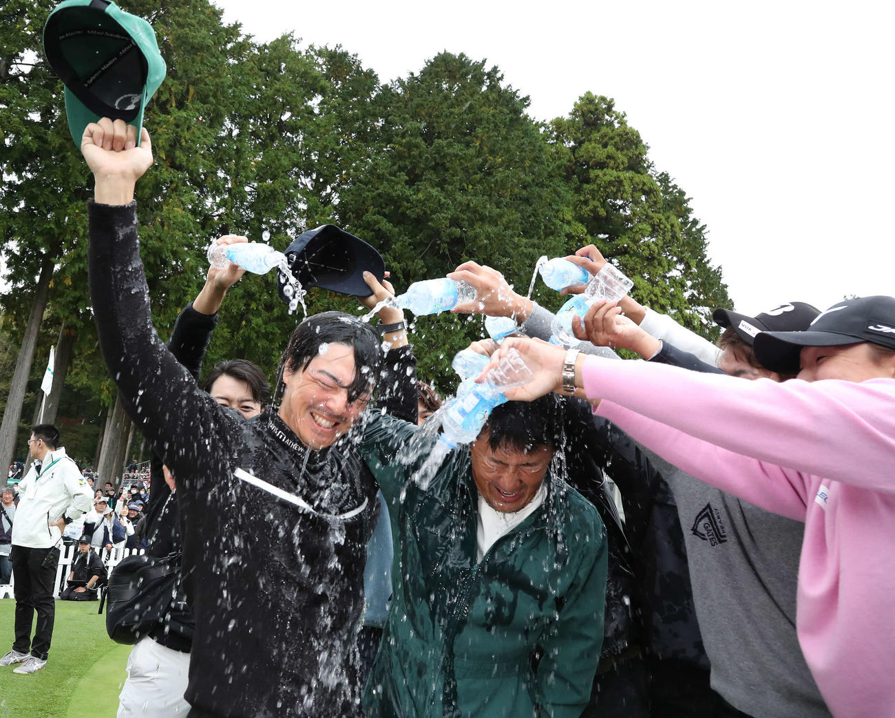 逆転優勝して佐藤キャディーと共にウォーターシャワーの祝福を受ける石川遼（撮影・丹羽敏通）