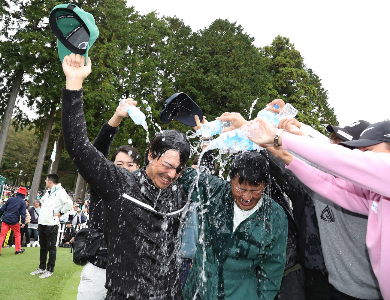 逆転優勝して佐藤キャディーと共にウォーターシャワーの祝福を受ける石川遼（撮影・丹羽敏通）