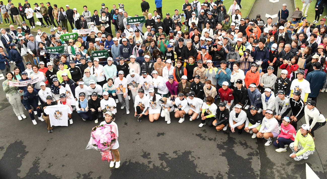 今季限りで第一線を退く上田（花束）は女子プロ仲間やギャラリーと記念撮影（撮影・前岡正明）