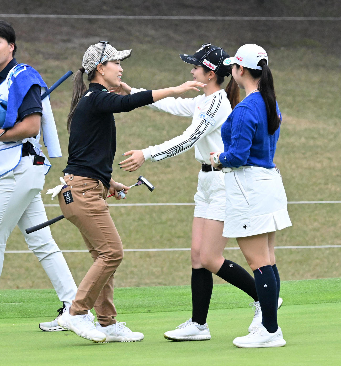 18番、ホールアウトした上田（左）は川崎春花とハグ。右は小祝（撮影・前岡正明）