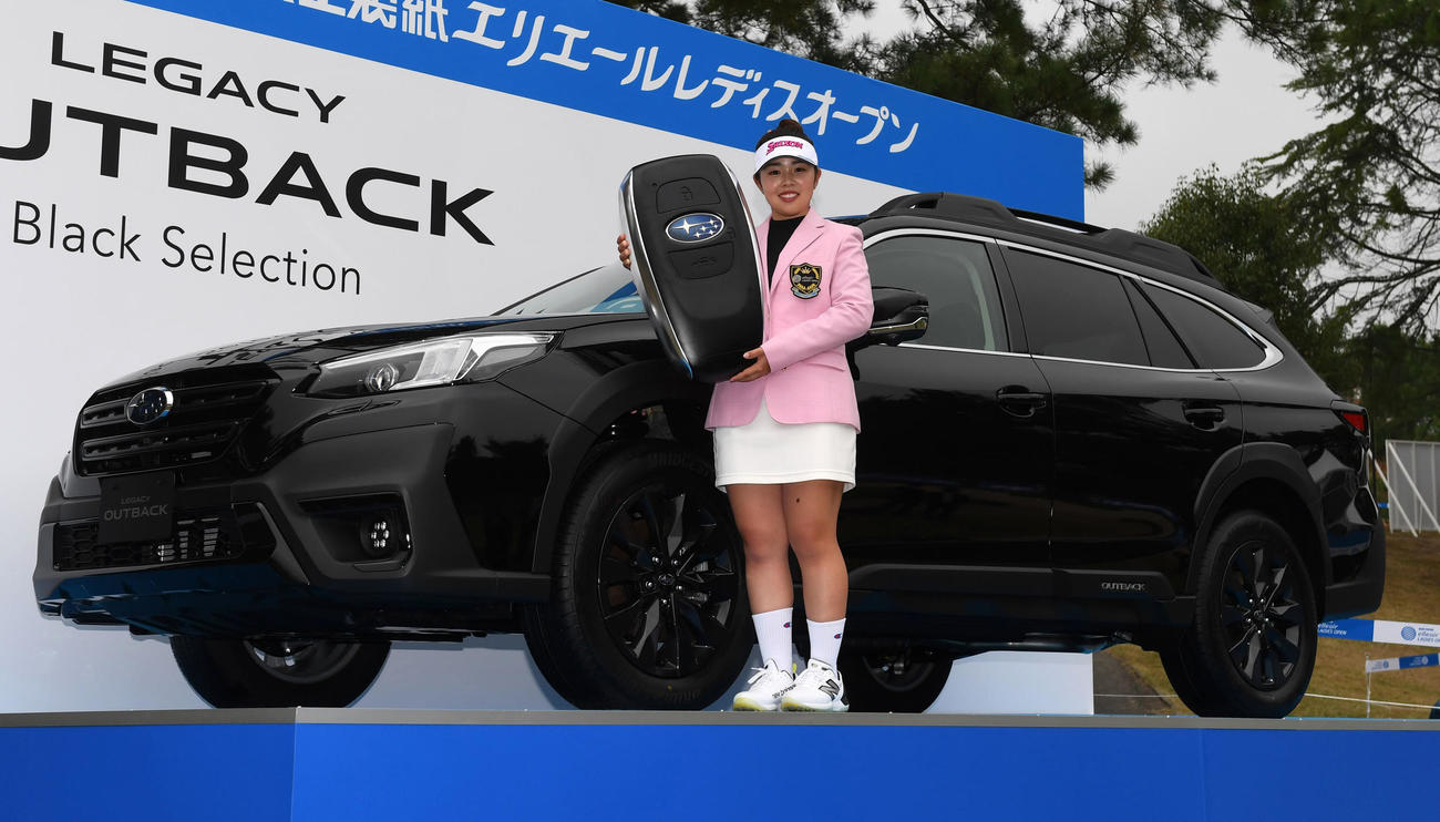 優勝した山下は副賞の車の前で笑顔を見せる（撮影・前岡正明）