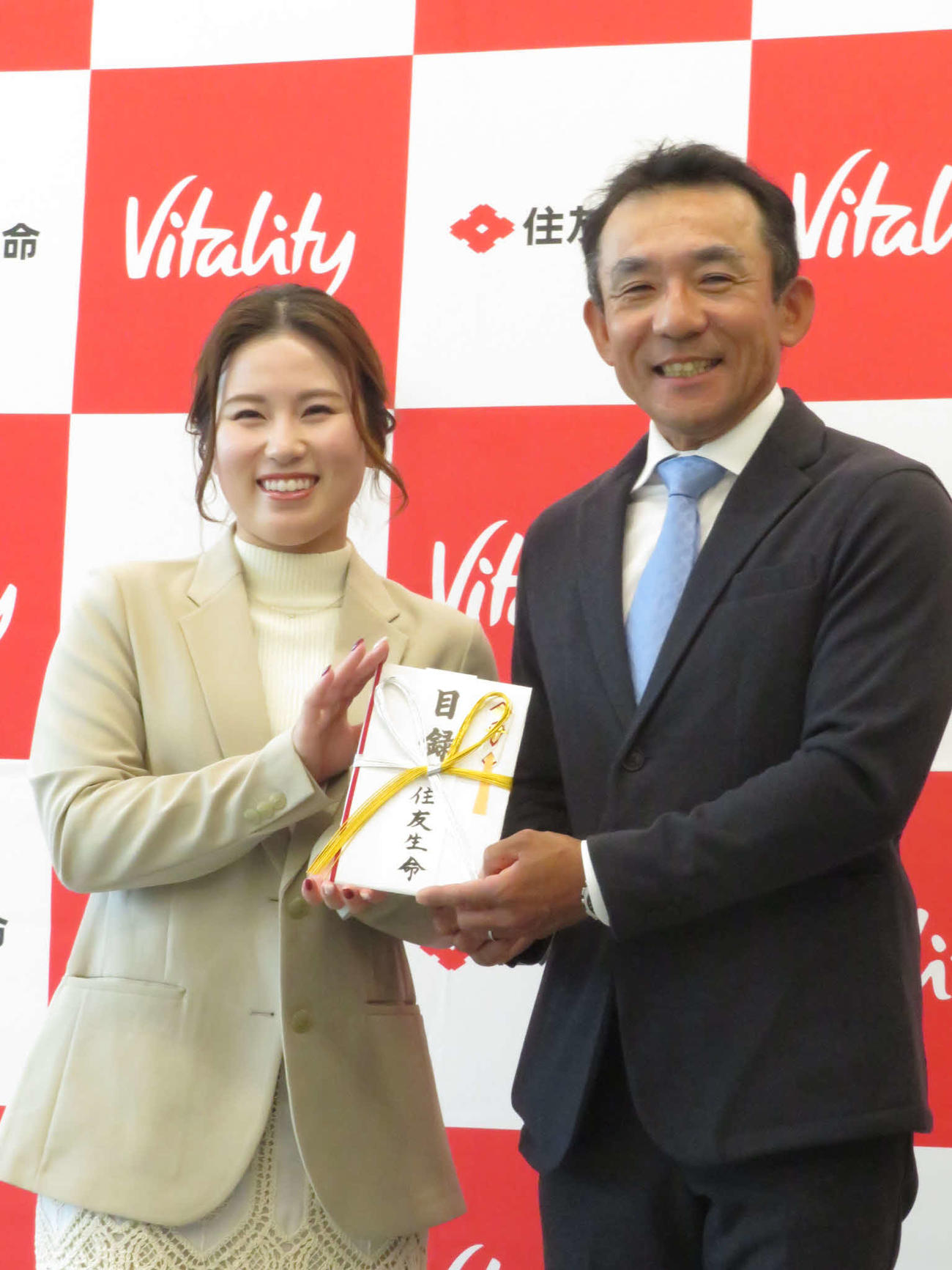日本プロキャディー協会の森本代表理事（右）に寄付金を贈呈した西村