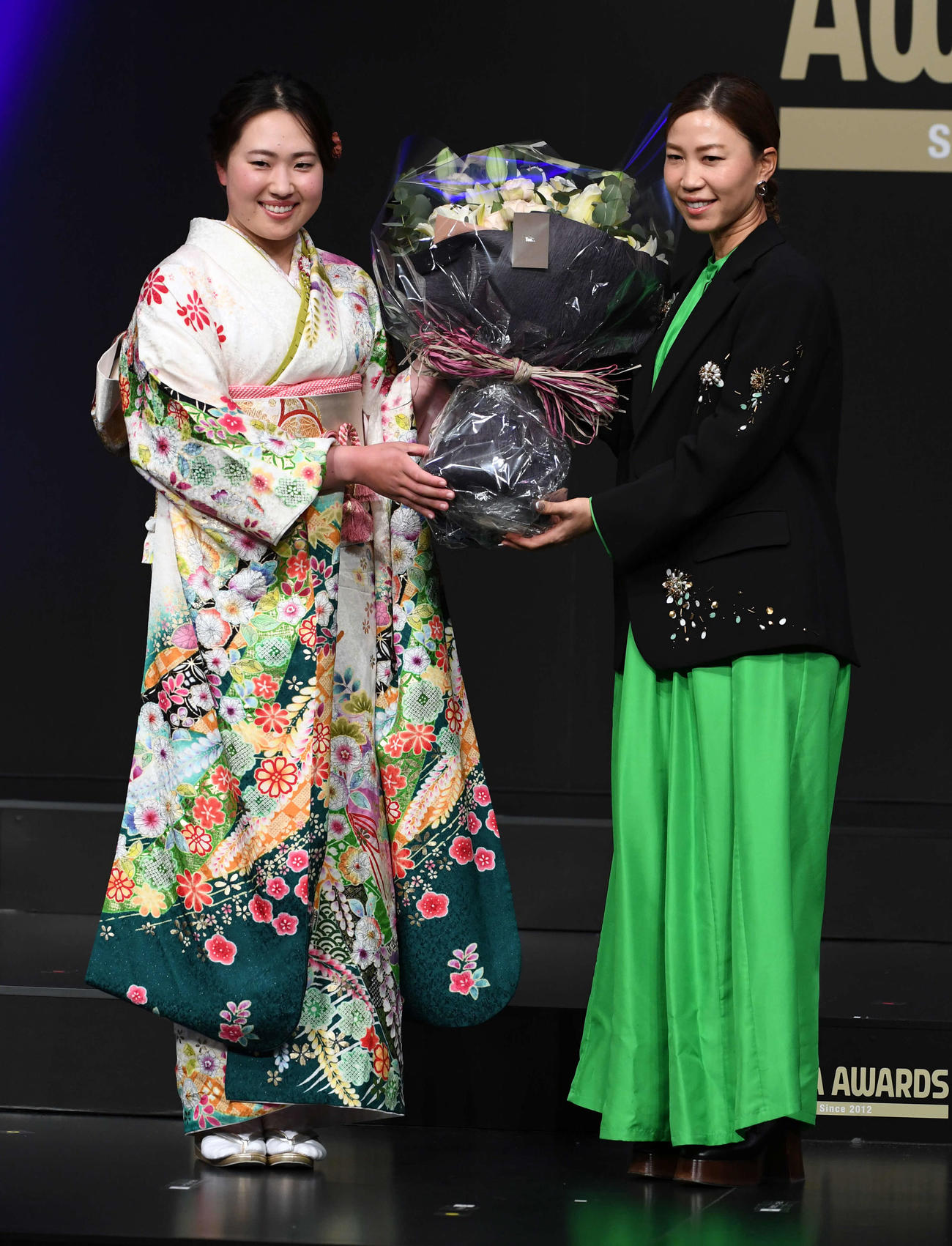 「JLPGAアワード2024」で、特別功労賞の上田桃子（右）は竹田麗央から花束を贈られる