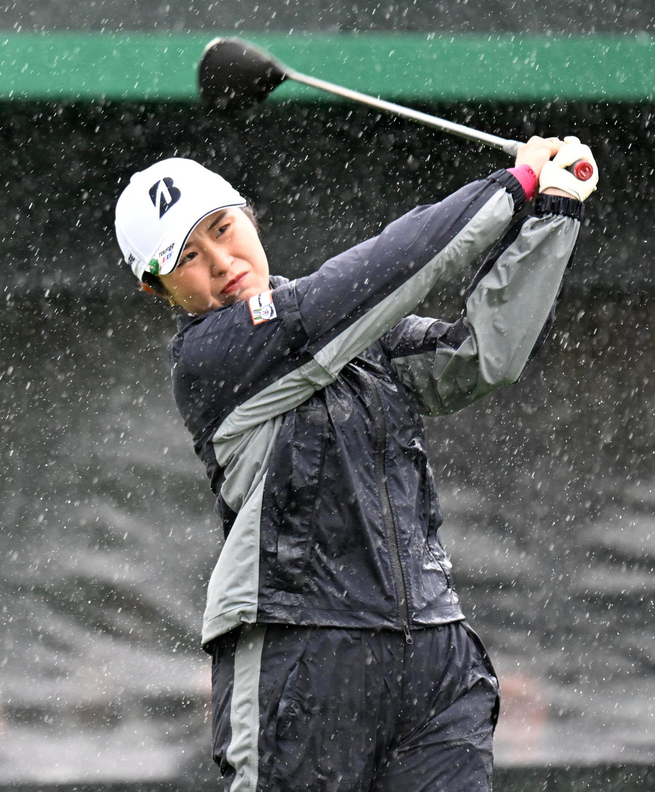 1番、激しい雨の中、ティーショットを放つ大里（撮影・前岡正明）