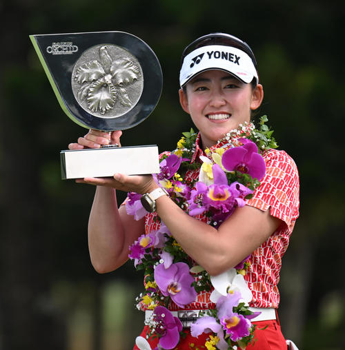 10アンダーで大会連覇を達成、優勝トロフィーを手に笑顔を見せる岩井千（撮影・前岡正明）
