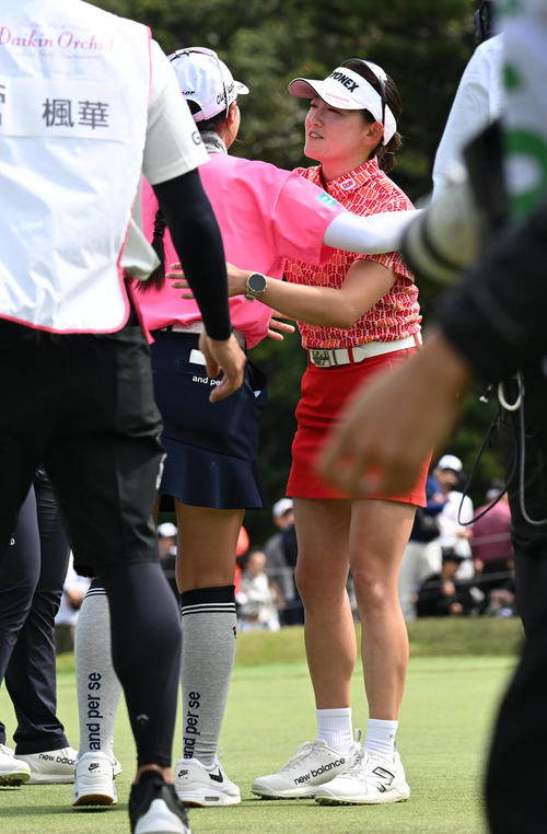 18番、バーディーパットを決め10アンダーで大会連覇を達成、菅（背中）と健闘をたたえ合う岩井千（撮影・前岡正明）
