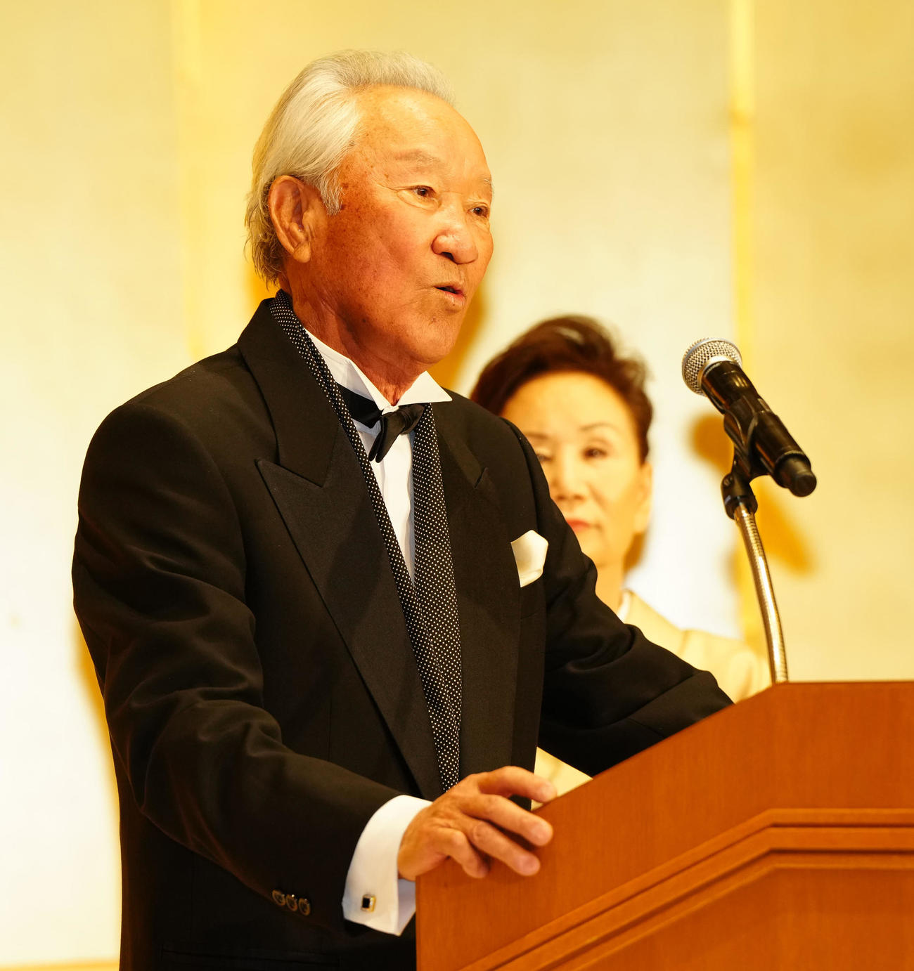 文化功労者顕彰を祝う会であいさつする青木。後方はチエ夫人（撮影・江口和貴）