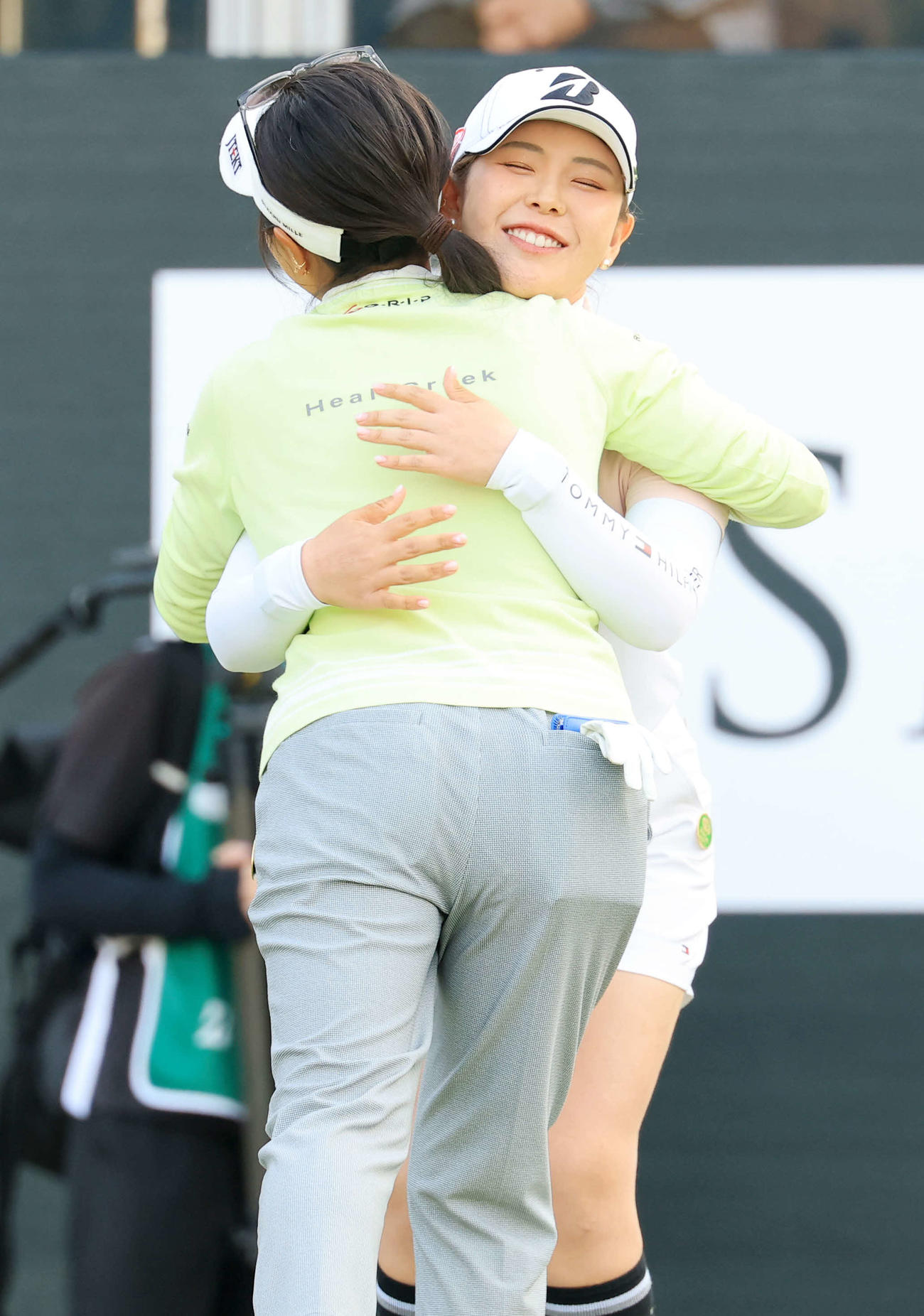 第2日　18番を終え、青木瀬（手前）と笑顔で抱擁する吉田優（撮影・浅見桂子）