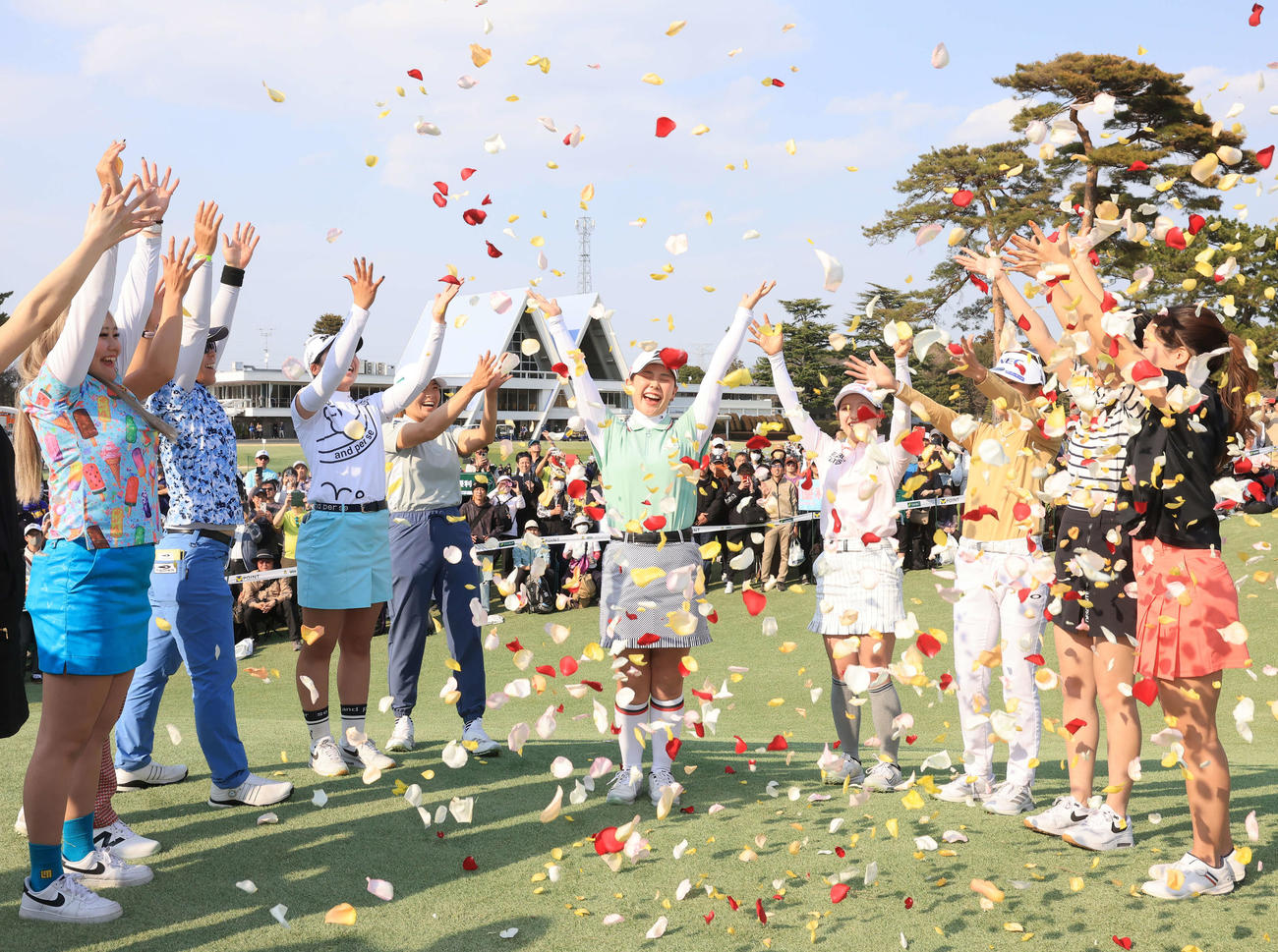 最終日　圧勝Vの吉田優（中央）は、渋野（後方左）、吉田鈴（同右）ら選手からフラワーシャワーの祝福を受け笑顔でバンザイ（撮影・浅見桂子）