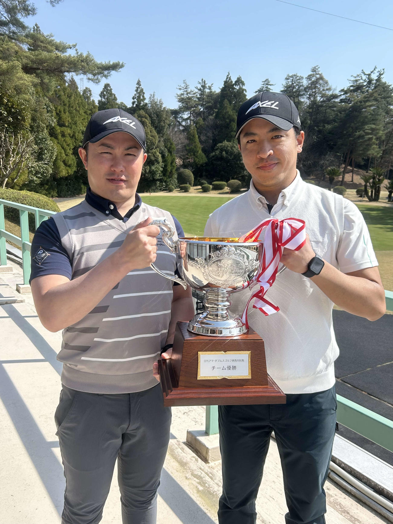 東西対抗戦を制し、優勝カップを掲げる関西代表の稲葉・三上（右）ペア