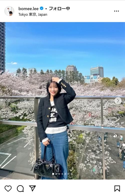 ボミちゃんが桜をバックに、黒のトップスとデニムのコーデ「すてきです
