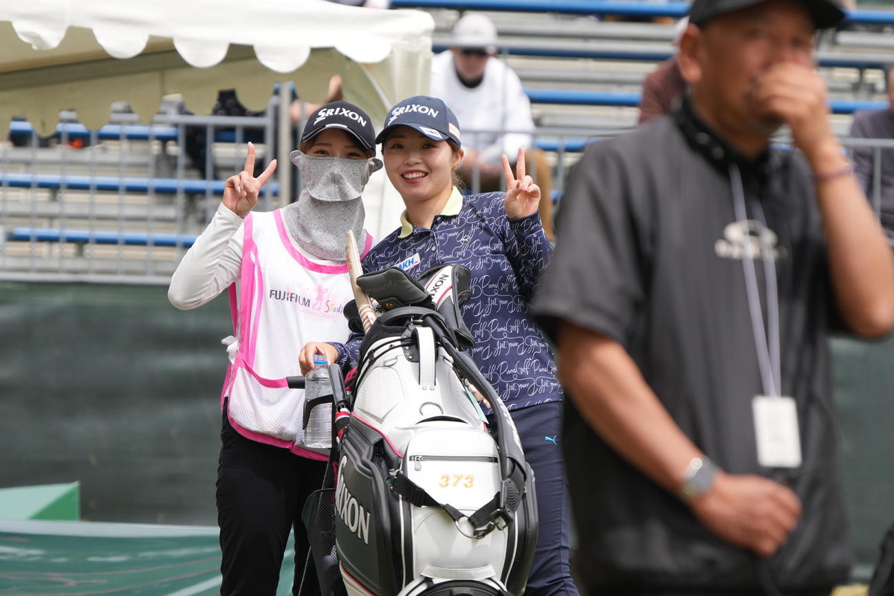 1番、ティーショットの前にカメラマンに向かってキャディとピースする高久＝2025年4月11日