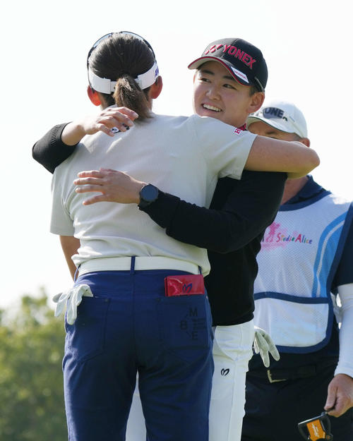 18番、中断されていた第1日のプレーを終え抱き合う岩井千（左）、岩井明姉妹（撮影・小沢裕）