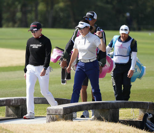 18番、談笑しながらグリーンへ向かう橋を渡る岩井明（左）、岩井千姉妹（撮影・小沢裕）