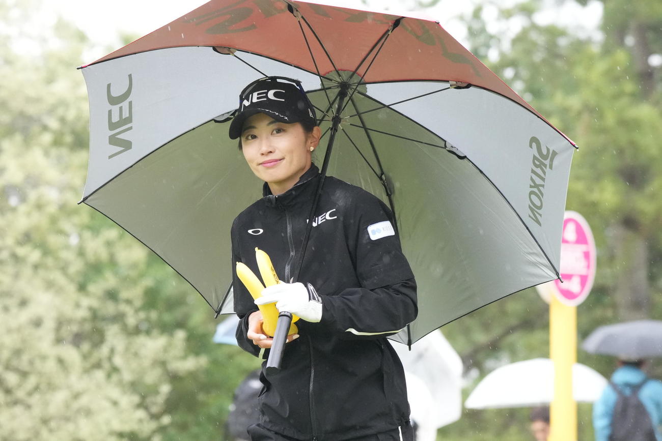 4番、ティーショットを終え傘をさしながら移動する安田祐（撮影・小沢裕）